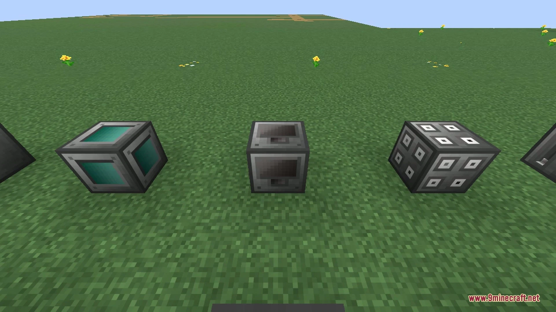 A row of Big Reactors component blocks laid out on the ground, including reactor casing, ports, reactor glass, and other coloured multiblock parts.